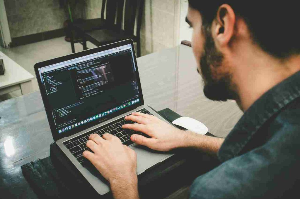 Un hombre con un ordenador tratando de encontrar la solución a borrar texto en PDF